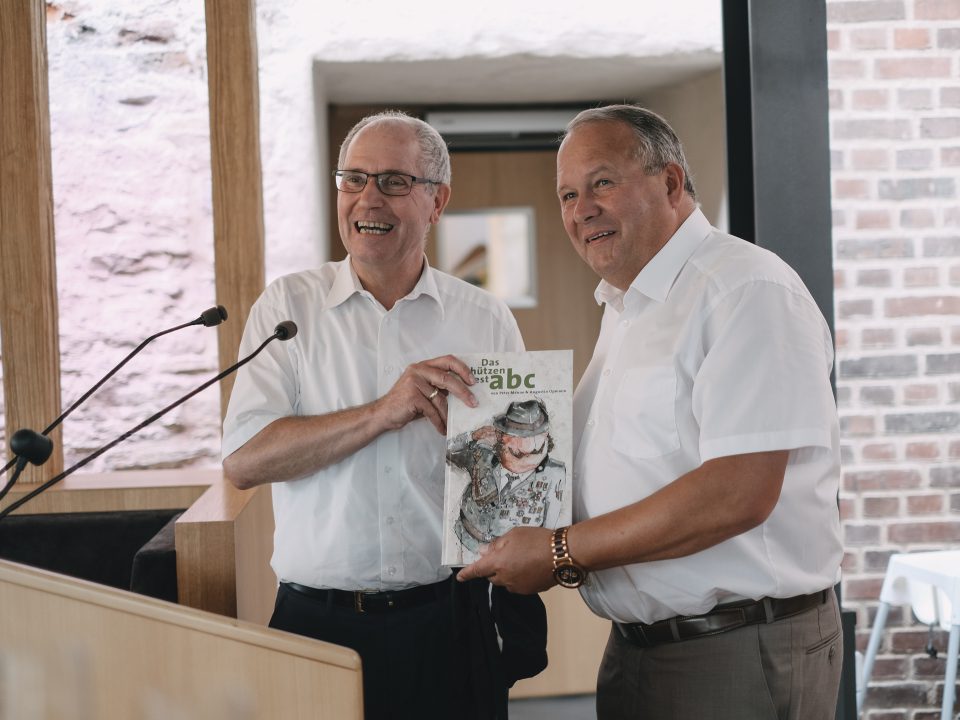 Manfred Müller überreicht Josef Hovenjürgen das Schützenfest-abc